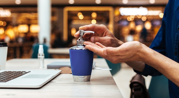 Fermer. homme appliquant un gel décontaminant sur ses mains. photo avec un espace de copie