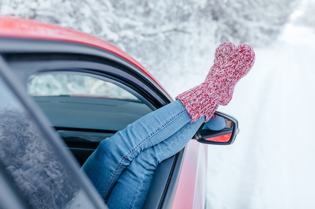 Fermer. Jeune femme en chaussettes chaudes au repos à l'intérieur de la voiture.