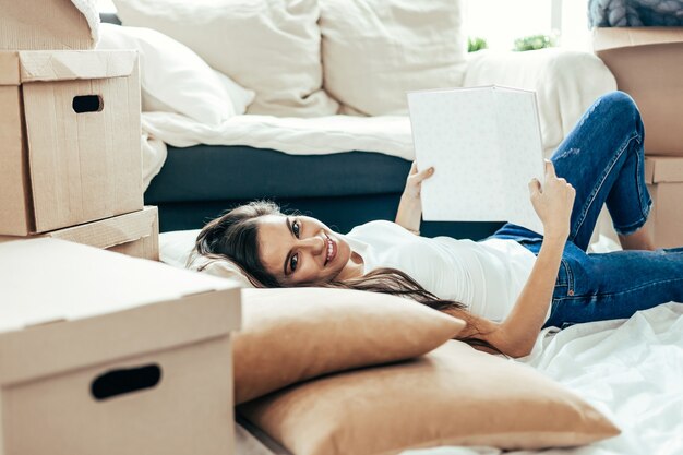 Fermer. jeune femme avec un projet de son appartement allongé sur le sol.