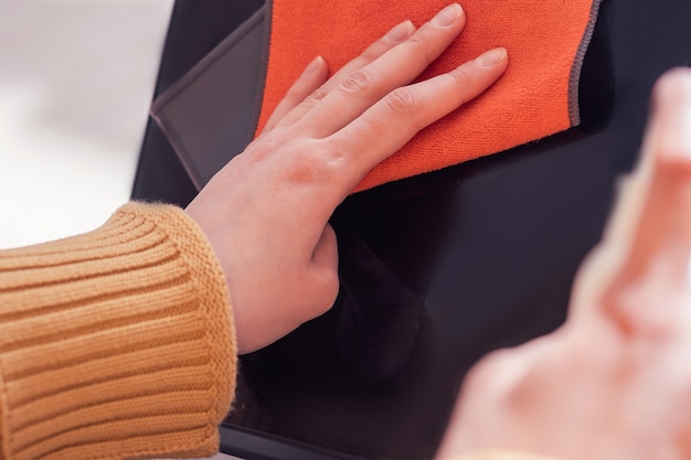 Fermer. une jeune femme utilise un antiseptique pour nettoyer son ordinateur portable. photo avec une copie de l'espace