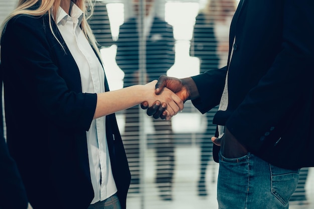 Fermer. jeunes partenaires commerciaux se serrant la main. le concept de coopération