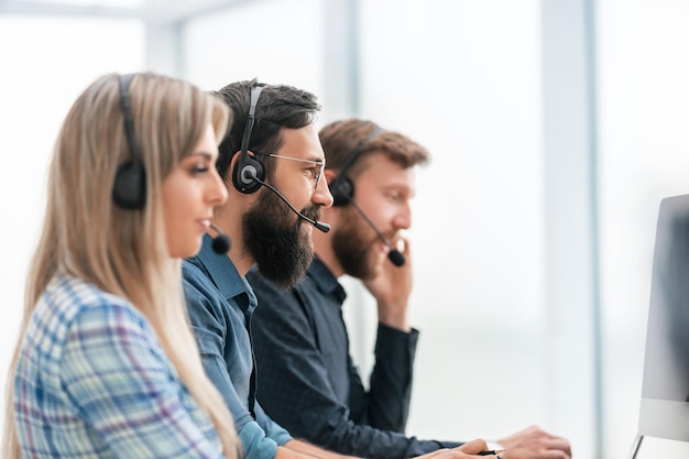 Fermer. Ligne d'employés du centre d'appels travaillant sur des ordinateurs