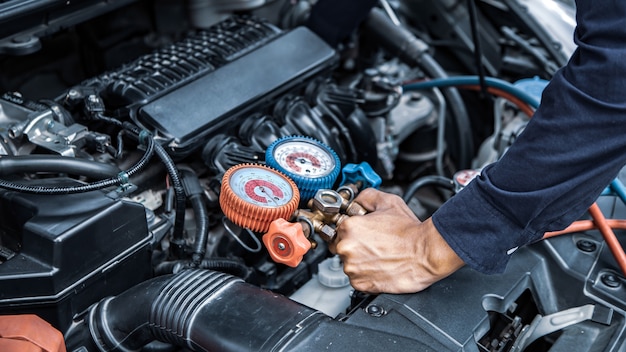 Fermer la main à l'aide de la jauge de collecteur pour remplir les vieux climatiseurs de voiture.