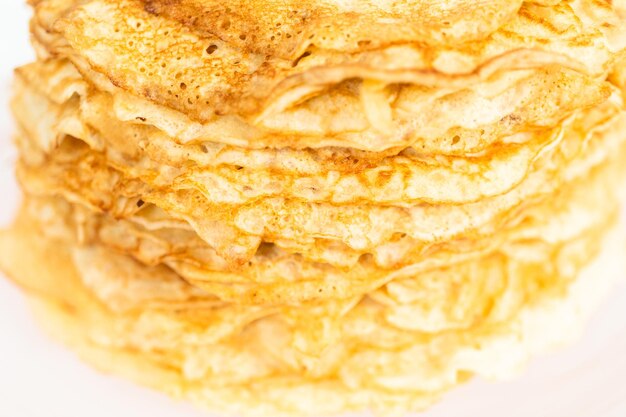 Fermer. Pile de crêpes fraîchement cuites sur un stand de gâteau.