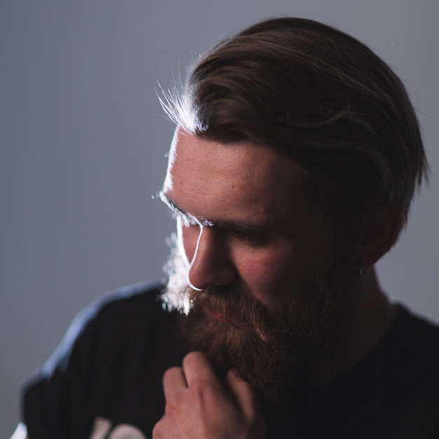 Fermer. portrait d'un homme barbu maussade. isolé sur fond sombre