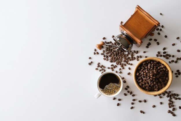 Fermer la vue des grains de café avec tasse à café et moulin