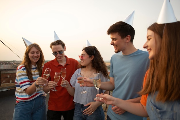 Fermez les amis avec des chapeaux de fête