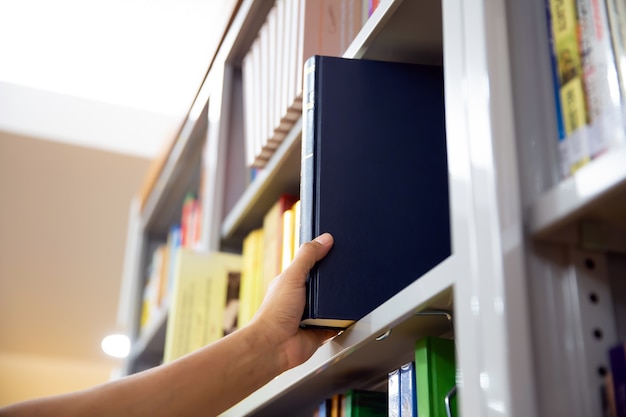 Fermez la main en choisissant un livre dans la bibliothèque.