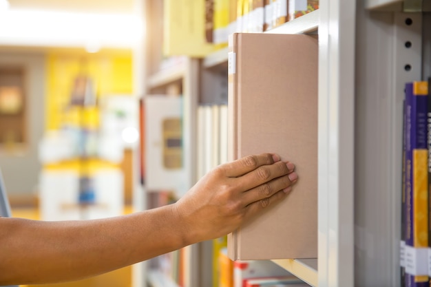 Fermez la main en choisissant un livre dans la bibliothèque.