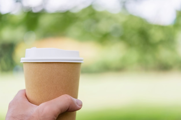 Fermez la main du mâle en tenant la tasse de café.