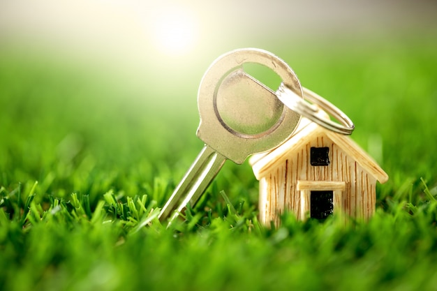Fermez place modèle de maison sur l'herbe verte pour l'hypothèque à la maison et le prêt, le refinancement ou un investissement immobilier