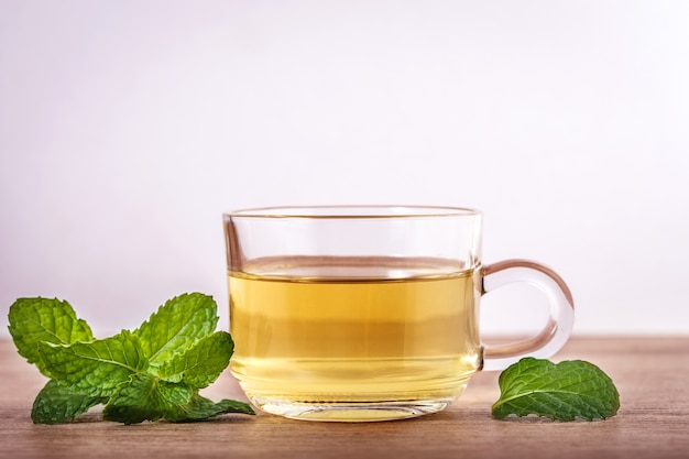 Fermez une tasse de thé à la menthe avec des feuilles vertes de menthe poivrée