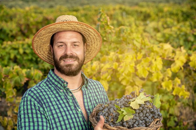 Fermier barbu dans le vignoble avec du vin de raisin