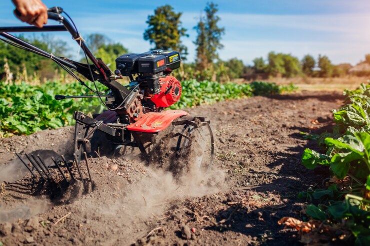 Photo fermier conduisant un petit tracteur pour la culture du sol et la récolte de pommes de terre.