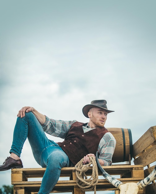 Fermier cowboy homme dans la campagne portant chapeau de cowboy occidental modèle masculin américain dans la campagne sur f