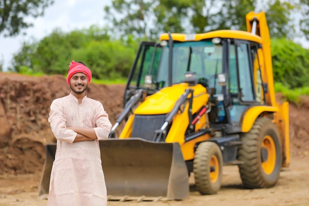 Fermier indien debout avec ses nouvelles machines de terrassement.