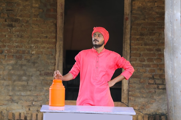 Fermier indien tenant une bouteille de lait en main à la ferme laitière