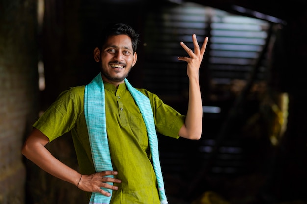 Fermier indien en tenue traditionnelle et donnant une expression heureuse à la maison