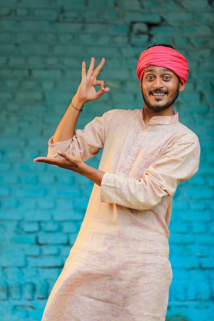 Fermier indien en tenue traditionnelle et donnant une expression heureuse à la maison