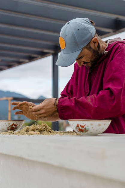 Fermier séparant les graines d'oignon dans un bol.