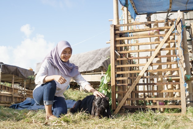 Fermière musulmane nourrir les animaux sur la ferme traditionnelle