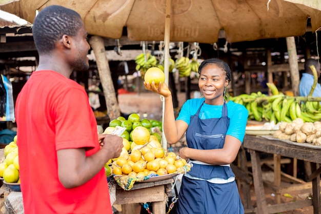 Fermière noire vendant des fruits à un jeune homme