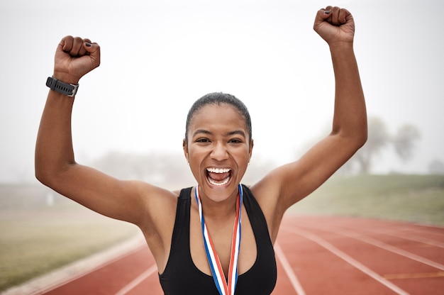 Féroce face à l'adversité. Photo d'une belle jeune athlète féminine célébrant la fin de sa course.