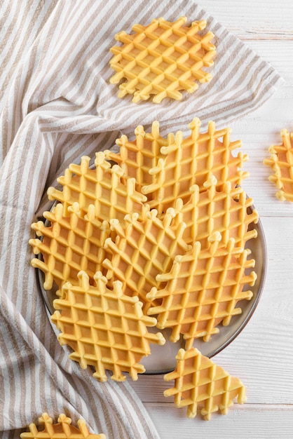 Ferratelle ou pizzelle un dessert traditionnel ou des biscuits des Abruzzes sur une assiette sur une vue de dessus de fond en bois blanc