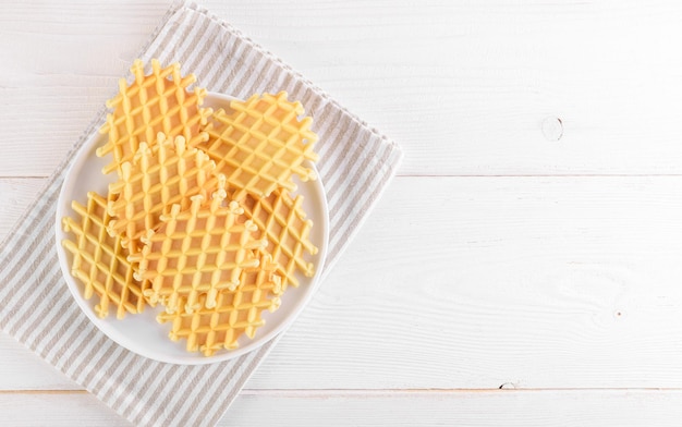 Ferratelle ou pizzelle un dessert traditionnel ou des biscuits des Abruzzes sur une assiette sur une vue de dessus de fond en bois blanc