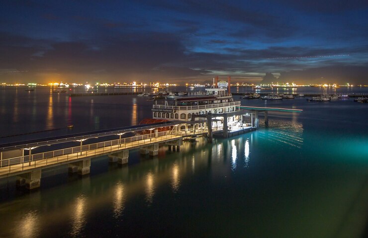 Photo le ferry amarré sur une jetée éclairée contre le ciel au coucher du soleil