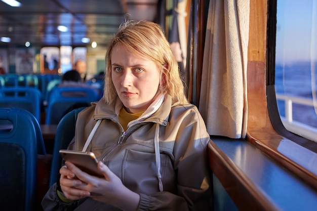 Ferry cabine passagers femme triste textos avec quelqu'un en ligne à l'aide d'un smartphone