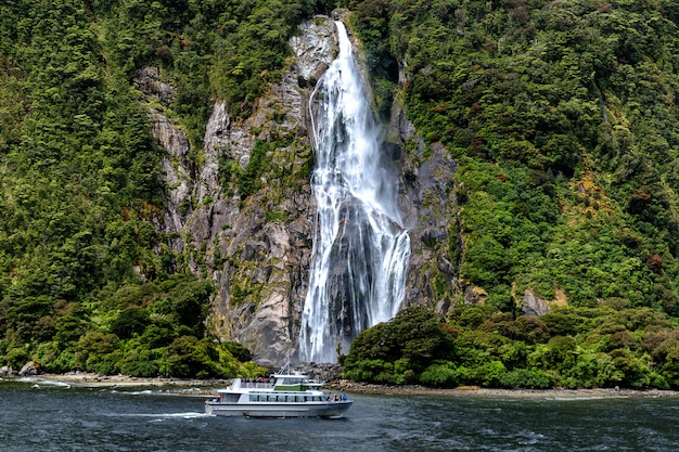 Ferry de croisière et belle cascade haute à Milford Sound