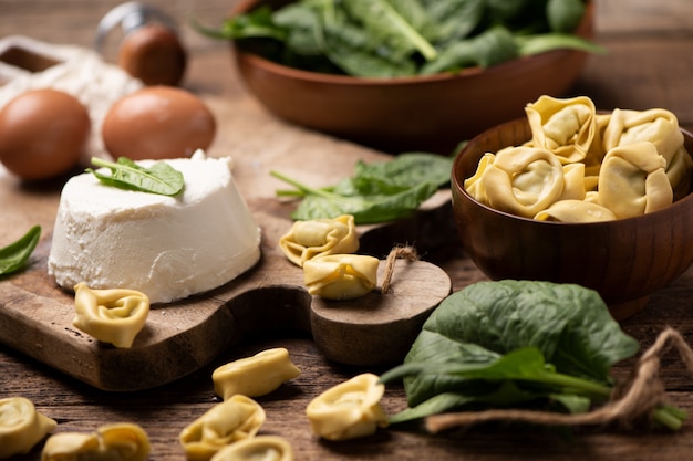 Fesh tortellini raviolis sur table rustique en bois avec épinards et ricotta