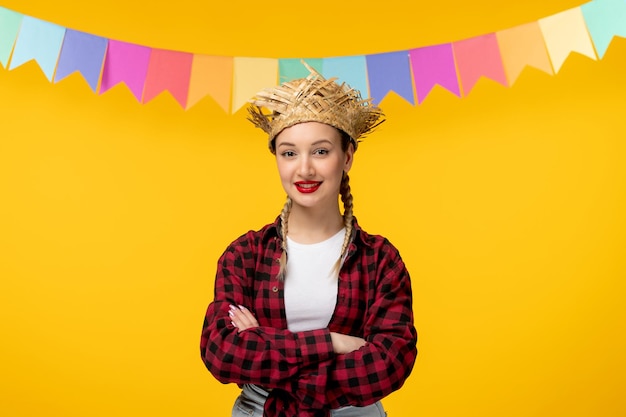 Festa junina blonde jolie fille au chapeau de paille festival brésilien avec des drapeaux colorés mains croisées