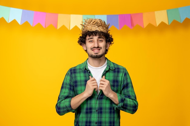 Festa junina jeune mec mignon en chapeau de paille et chemise de boutonnage du festival brésilien de drapeaux colorés