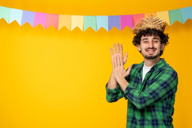 Festa junina jeune mec mignon en chapeau de paille et drapeaux colorés festival brésilien applaudissant les mains