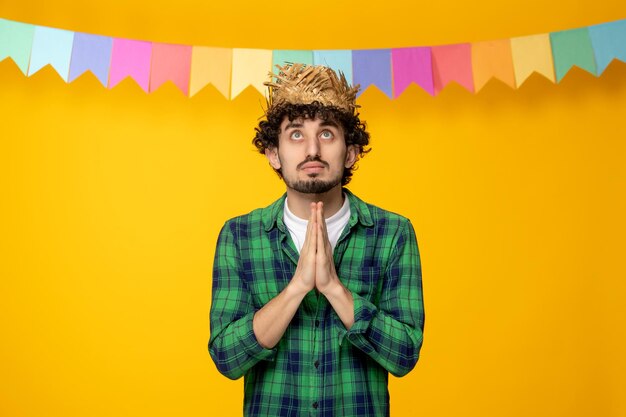 Festa junina jeune mec mignon en chapeau de paille et drapeaux colorés festival brésilien priant