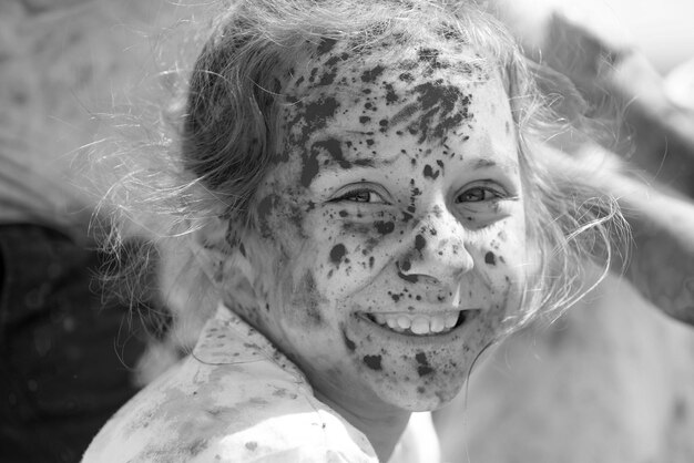 Le festival de Holi d'enfant a peint le visage d'un petit garçon drôle d'enfant joue avec des couleurs