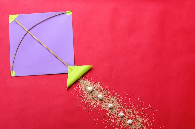 Festival indien makar sankranti concept, cerf-volant coloré, ficelle et boule de graines de sésame sucré.