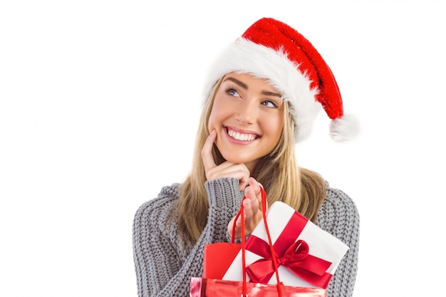 Festive blonde tenant le cadeau de Noël et sac