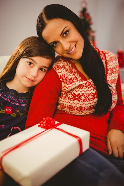 Photo festive mère et fille tenant le cadeau de noël