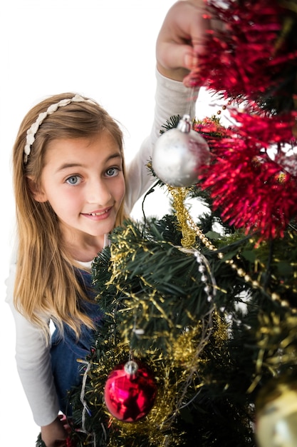 Festive petite fille décorer le sapin de Noël