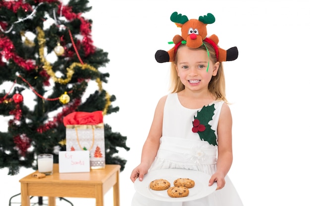 Festive petite fille tenant des biscuits frais