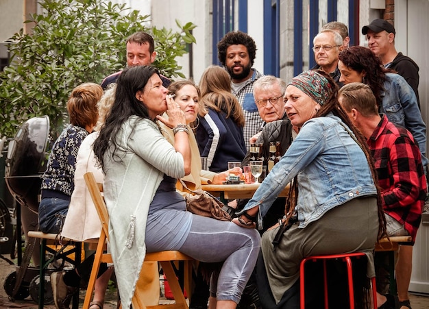 Une fête amicale d'hommes et de femmes buvant de la bière dans une rue de la ville de Hollande, Pays-Bas