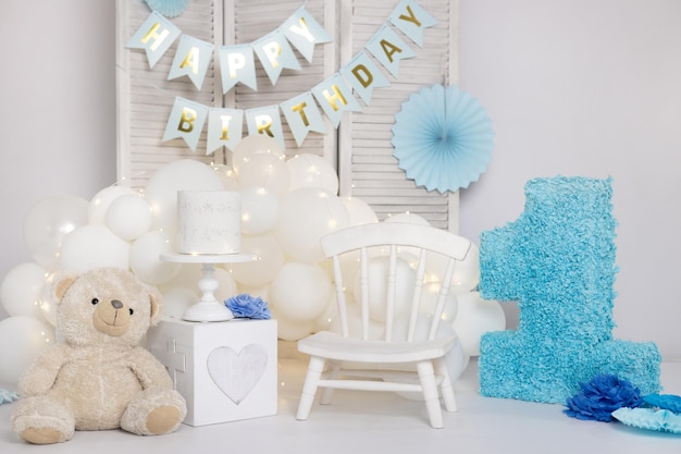 Fête d'anniversaire d'un an pour petit enfant avec décor mignon de gâteau à la crème blanche et papier bleu numéro un