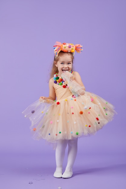 Fête D'anniversaire Pour Enfants, Mascarade. Petite Fille Enfant Bambin Heureux Dans Un Déguisement De Tutu Gonflé, S'amuser Sur L'espace Violet. Espace Pour Le Texte