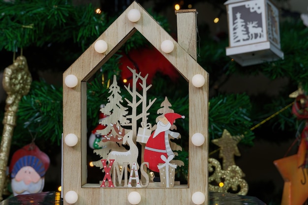 Fête de l'Avent Décoration en bois de Noël avec la figure du Père Noël et le signe de Noël avant l'arbre décoré