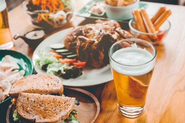 Photo fête de la bière et poulet grillé heureux de profiter à la maison