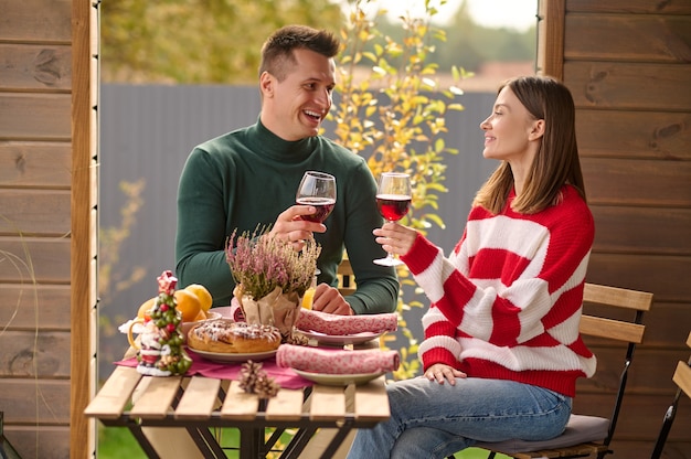 Fête. Un couple assis à table avec des verres de vin dans les mains