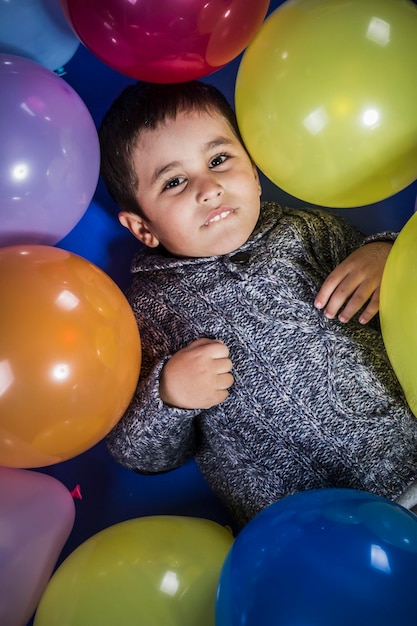 Fête de décoration, garçon jouant avec des ballons de plusieurs couleurs